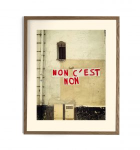 Photographie encadrée d'un mur urbain avec l'inscription en lettres rouges « NON C'EST NON »